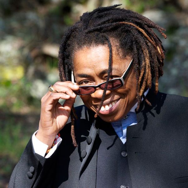 Melanie DeMore ©Lifestyle Child Theme on Genesis Framework African American composer Melanie DeMore wearing a dark concert suit, smiling broadly at the camera over sunglasses