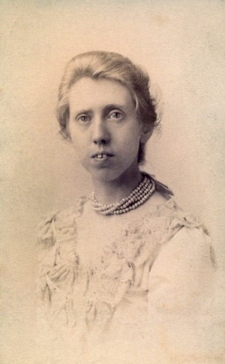 Emma Mundella - photographer unknown composer Emma Mundella circa 1890 with loose blonde hair tied back, wearing a taffeta dress and a pearl-effect necklace