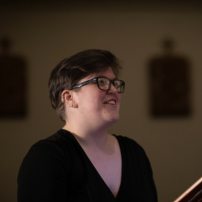Caroline Lesemann-Elliot - photographer unknown composer Caroline Lesemann-Elliot with very short brown hair and thick-rimmed dark glasses wearing a black top