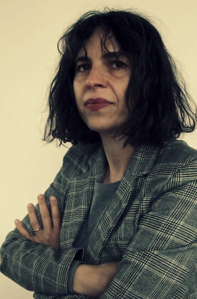 Carlotta Ferrari - photographer unknown Italian composer Carlotta Ferrari with dark wavy hair wearing a grey top and grey and cream chequered jacket